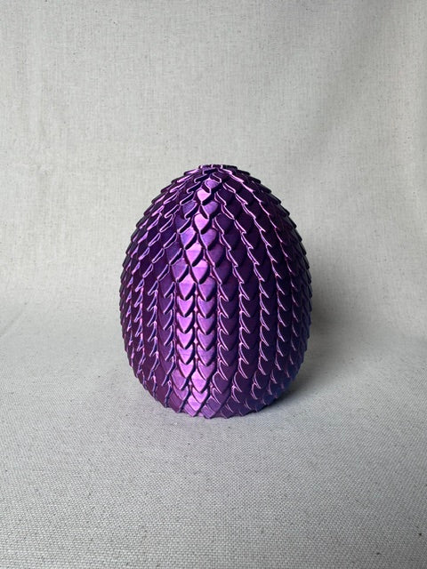 3D printed purple and blue articulated dragon emerging from a scale egg.