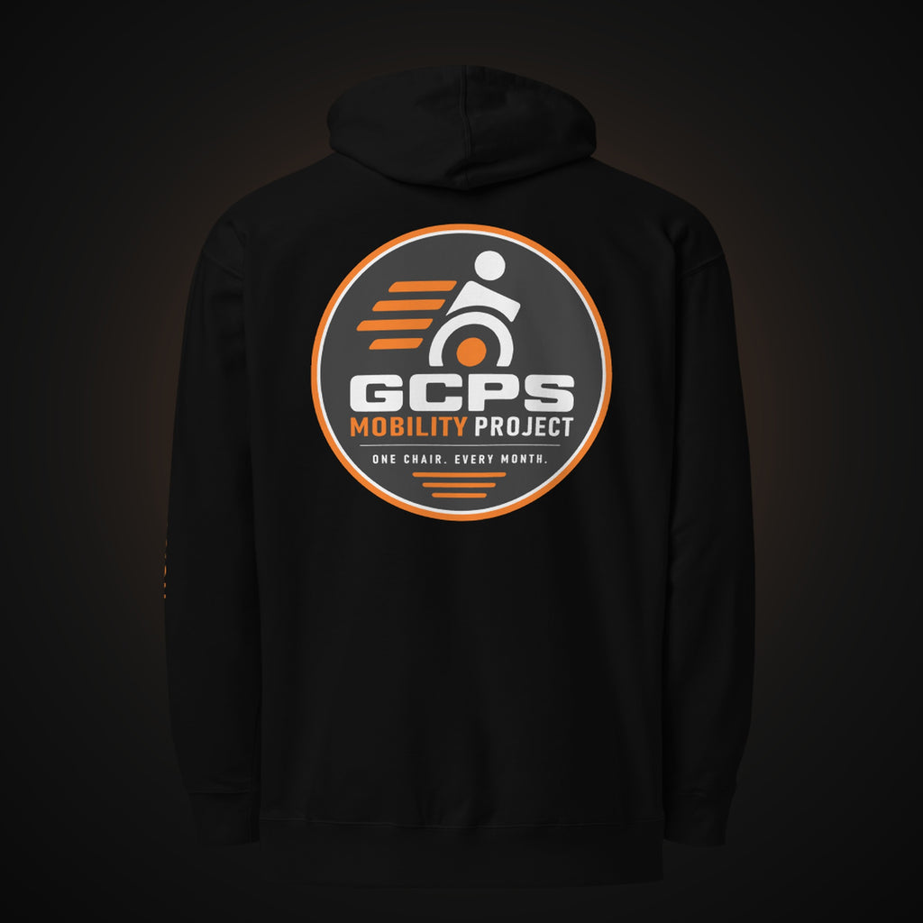 Back of the black GCPS Mobility Project Hoodie with a large orange, gray and white GCPS Mobility Project badge reading "One Chair. Every Month."