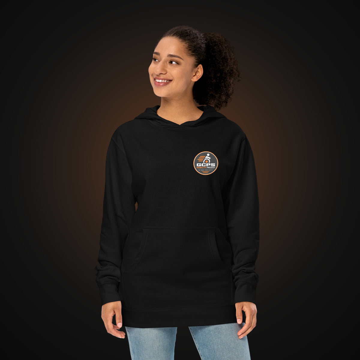 Person wearing the black GCPS Mobility Project Hoodie, front view with the left chest badge