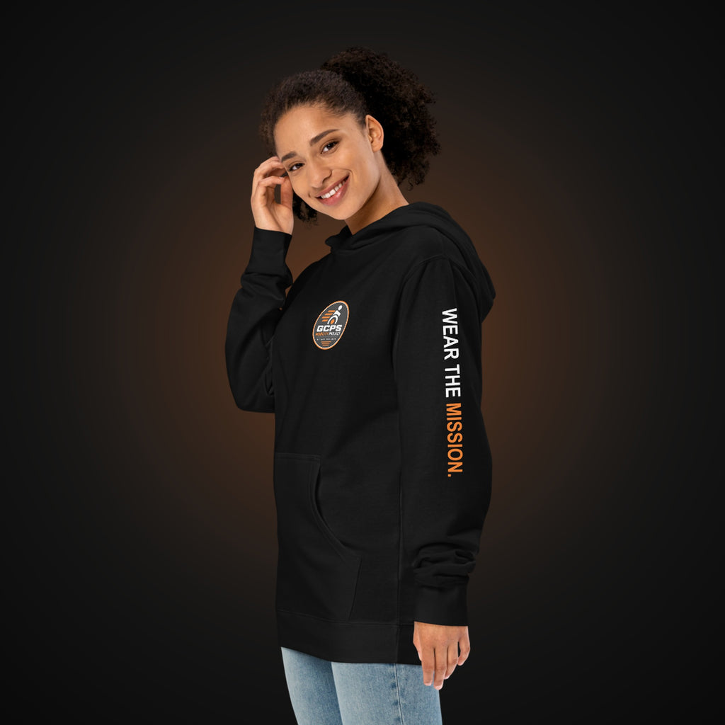 Person wearing the black GCPS Mobility Project Hoodie, angled view showing the "Wear the Mission" sleeve print