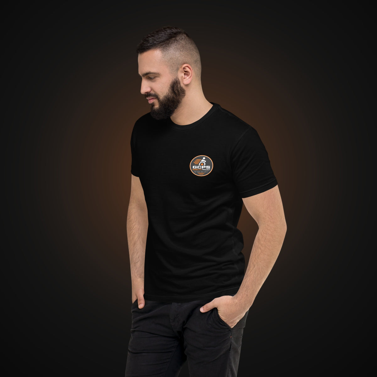 Person wearing the black GCPS Mobility Project T-Shirt, angled view showing the left chest badge